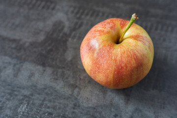 Ripe red apple on a gray background. Selective focus.