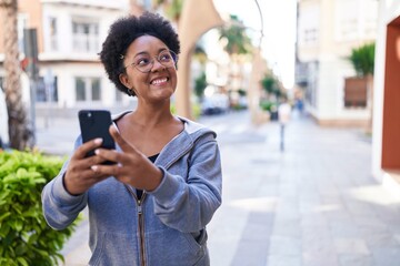 African american woman smiling confident using smartphone at street