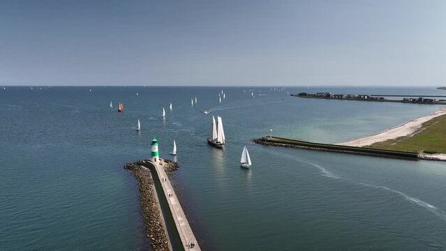 Aerial footage of a tall ship and a sailing boat passing through the entrance from the Baltic Sea into the Schlei. The lighthouse of schleim&uuml;nde by Lotseninsel  (pilot island) at the mouth of  Schlei.