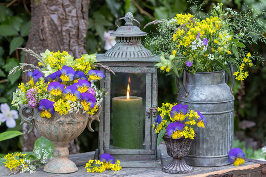 vintage Arrangement mit Blumenstrauß mit Hornveilchen, echtem Labkraut und Wiesenblumen  und Laterne	