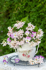 Obraz na płótnie Canvas Blumenstrauß mit pink Hornveilchen und Weigelien-Blüten in vintage Zuckerdose