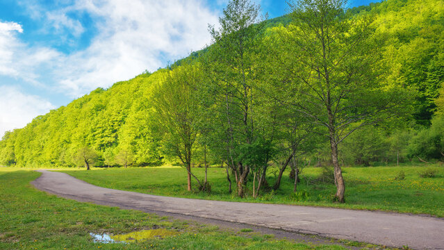 peaceful scenery, surrounded by the green hills and majestic mountains. road runs through the rural landscape, providing a picturesque view of the peaceful morning