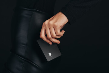 Getting a hold on the pulse of modern banking: Female hand holds a premium bank card in a studio setting