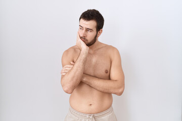 Fototapeta premium Young hispanic man standing shirtless over white background thinking looking tired and bored with depression problems with crossed arms.