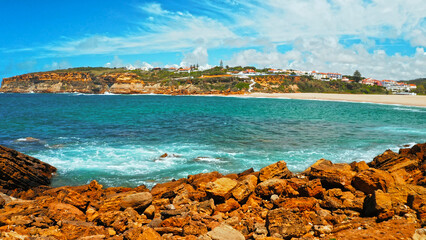 Obraz premium Beautiful sandy beach on summer sunny day with azure water. Aerial view: beach with white sand and blue water. Drone view of scenic nature in Portugal. Beautiful seascape in Europe