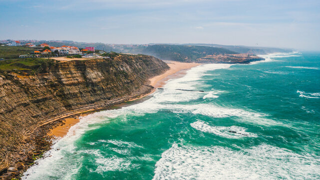 Drone  view over long rocky coastline in Ericeira, Portugal, on summer sunny day.  Top view - Beautiful natural landscape with ocean rocky shore. Aerial view over Scenic European tourist destination.