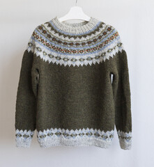 Icelandic wool knitted lopapeysa sweater, brown green pullover with large colorful yoke in traditional Nordic knitting pattern
