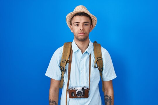Brazilian young man holding vintage camera relaxed with serious expression on face. simple and natural looking at the camera.