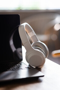 Modern wireless headphones and laptop computer while resting. Set up a workspace or home office to work from home.