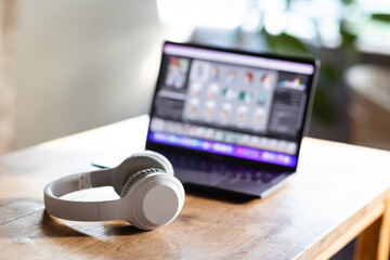 Obraz na płótnie Canvas Modern wireless headphones and laptop computer while resting. Set up a workspace or home office to work from home.