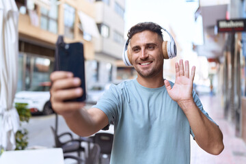 Young hispanic man smiling confident having video call at coffee shop terrace