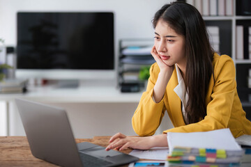 asian business woman thinking solving problem at work, worried serious young asian woman concerned make difficult decision lost in thought reflecting sit with laptop.