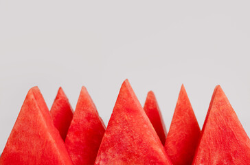 Slices of watermelon on grey background. Fresh red summer fruit. Healthy diet with delicious berry and vitamins. Copy space for text, front view. Clean eating, detox concept.