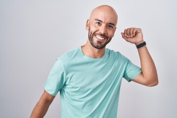 Middle age bald man standing over white background dancing happy and cheerful, smiling moving casual and confident listening to music