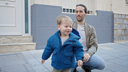 Father and son smiling confident at street