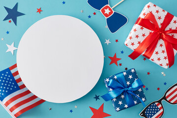 Fototapeta premium Idea for a Fourth of July party. Top view flat lay of gift boxes, american flag, Independence Day supplies, star-shaped confetti on pastel blue background with blank circle for text or advert