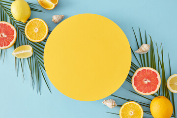 Summer fruit concept. Top view flat lay of orange lemon slices, grapefruit, palm leaves and...