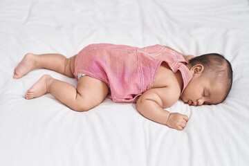 Adorable infant lying on bed sleeping at bedroom