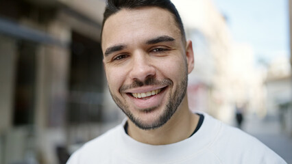 Young hispanic man smiling confident standing at street