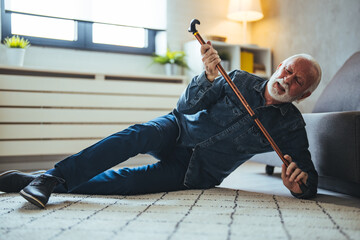  Senior man falling on the ground with walker in living room at home. Elderly older mature male...