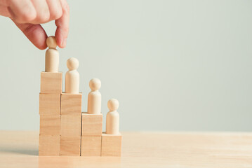 Hand placing officer job employee career position on wooden block steps stair background....