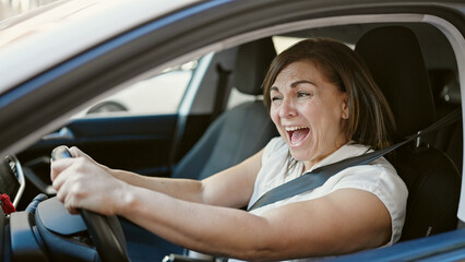 Fototapeta na wymiar Middle age hispanic woman stressed driving car at street