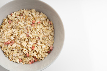 Fresh healthy breakfast of oatmeal and cereal with strawberries in a blue bowl on a white background isolate