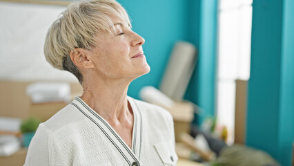 Middle age blonde woman smiling confident standing at new home