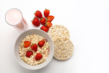 Fresh and healthy breakfast of strawberry yogurt, oatmeal with various cereals, strawberry cereal breads on a white table with a white background and reflection and space for text