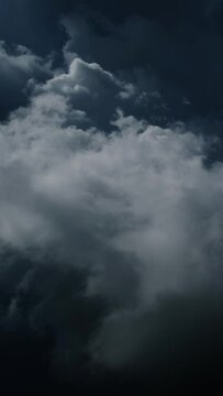 Lot of lightning during a thunderstorm. Storm clouds are moving fast on the viewer. Vertical video
