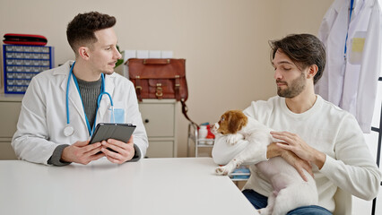 Two men having veterinarian consultation using touchpad at veterinary clinic