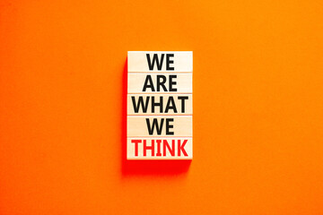 We are what we think symbol. Concept word We are what we think on wooden block. Beautiful orange table orange background. Business We are what we think concept. Copy space.