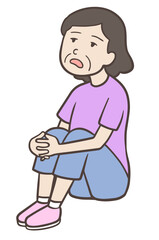 体育座りでぼんやりする中年女性