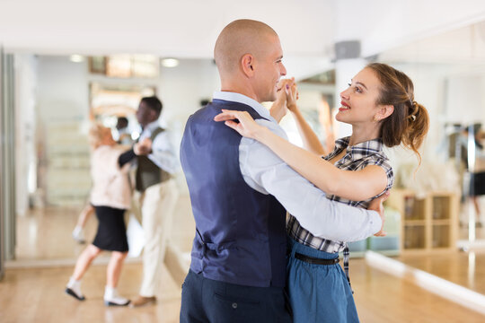 Happy man and woman enjoying ballroom dancing