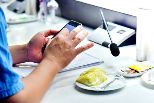 Close-up image of a woman using mobile phone in a cafe