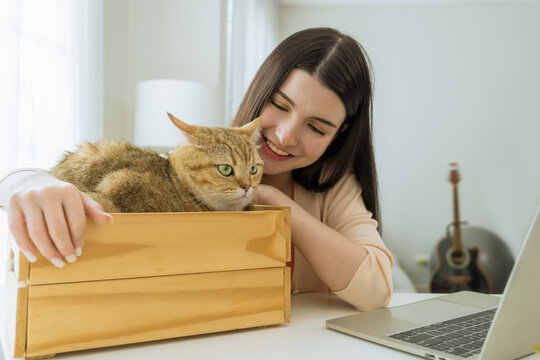 Young Asian woman enjoying time with her cat at home