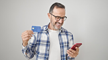 Middle age man using smartphone and credit card over isolated white background