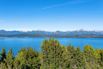 Fototapeta na wymiar Immerse yourself in the wilderness of Nahuel Huapi, where the shimmering lake harmoniously blends with untamed surroundings