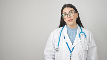 Young hispanic woman doctor standing with serious expression over isolated white background