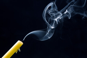 Smoke from an extinguished candle on a dark background. The concept of spirituality and the end of...