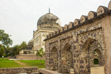 Corridor between tomb structures and the landscaped garden at Qutb Shahi Archaeological Park,...