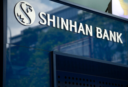 Ho Chi Minh City, Vietnam - May 22, 2023: White Shinhan bank logo and name on a blue ATM close-up. Advertisement of banking services of a Korean financial company