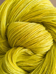 Yellow green yarn skein close up, hand dyed thin yarn flat lay top view