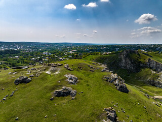 aerial view of Scene of a Shepherd with Sheep and Dog on top of rocky hill in corjeuti, moldova