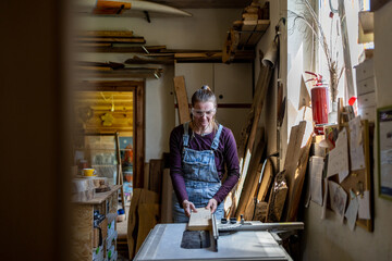 Craftswoman working with wood in carpentry workshop
