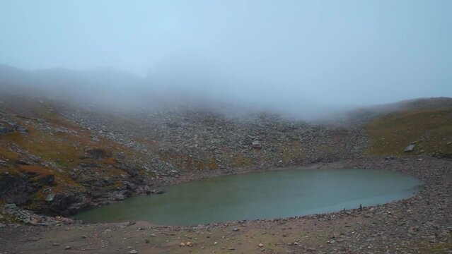 Holy Brigu Lake in Manali high on the mountains of Himalayas at Himachal Pradesh, India. Bhrigu lake covered with clouds in summer season. Mountain lake and clouds. Trekking in Himalayas.