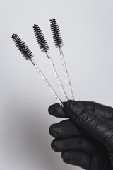 Close-up hand of master holds tools for eyebrow correction 