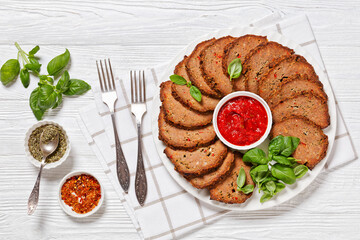 italian meatloaf cut in slices on white plate