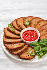 italian meatloaf cut in slices on white plate