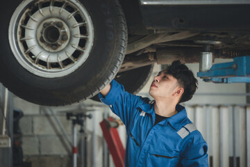 Fototapeta na wymiar Professional car mechanic checking car undercarriage, all types of car specialists, expert auto repair and accredited car repair centers.